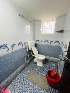 a bathroom with a toilet in a room with blue tiles at Manikya Homestay in Malpe +16 photos