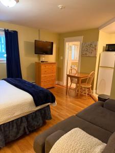 a bedroom with a bed and a table with a couch at Midstream Manor Unit 1, Studio in St. John's