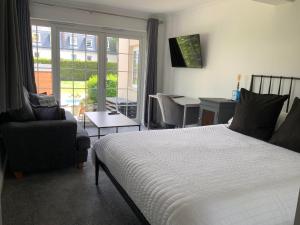 a bedroom with a bed and a chair and a table at The Albany Apartments in St Peter Port +25 photos
