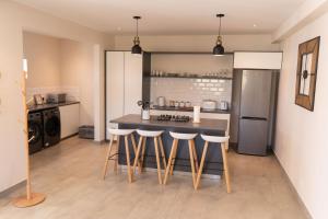 cocina con mesa y taburetes en 33C Kabeljauws Beach Estate, en Jeffreys Bay