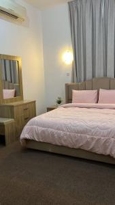 a bedroom with a bed with pink pillows and a mirror at Khalifa A Home Stay NR in Abu Dhabi