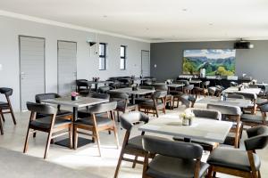 a dining room filled with tables and chairs at Khayalami Hotel - Secunda in Secunda
