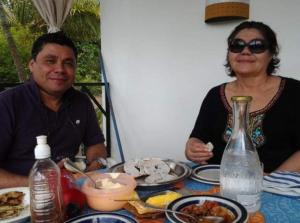 a man and a woman sitting at a table with food at Hotel suites Las Abuelas in Copán Ruinas
