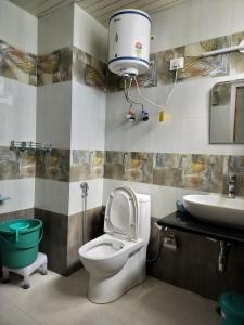 un baño con inodoro y lavabo en Hotel Midway Inn, en Jagatsukh