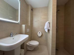 a bathroom with a sink and a toilet and a mirror at Hotel Bravo Iasi in Iaşi