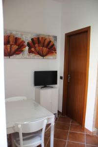 a room with a white table and a television at Pretty Favetti - lovely apartment in Trieste with a sea view - in Trieste