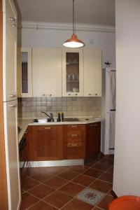 a kitchen with wooden cabinets and a sink at Pretty Favetti - lovely apartment in Trieste with a sea view - in Trieste +17 photos