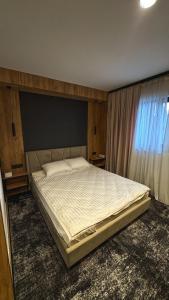 a bedroom with a large bed with a large window at Hostel Olevsk in Olevsk