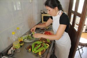 a woman standing in a kitchen preparing food at KiDRAK OTEL MONTENEGRO-1 in Faralya