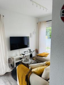 a living room with a couch and a flat screen tv at FeWo S26 in Krumbach
