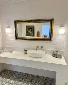 a white bathroom with a sink and a mirror at Romantic Wine Estate Stay in The Midlands in Howick