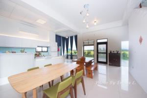 a kitchen and dining room with a wooden table and chairs at Colorful Fish Cottage in Zhuangwei