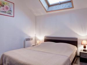 a white bedroom with a bed and a skylight at Appartement cosy 2 pièces avec balcon et parking, au centre de Brides-les-Bains, proche télécabine. - FR-1-512-204 in Brides-les-Bains