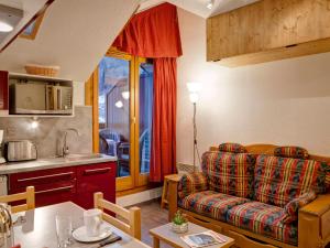 a kitchen and a living room with a couch and a table at Appartement cosy 2 pièces avec balcon et parking, au centre de Brides-les-Bains, proche télécabine. - FR-1-512-204 in Brides-les-Bains