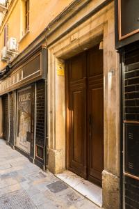 a building with two large brown doors on a street at NOMADIA en LARIOS STREET in Málaga