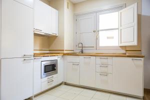 a white kitchen with white cabinets and a sink at NOMADIA en LARIOS STREET in Málaga
