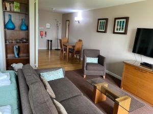 a living room with a couch and a tv and a table at Fell View in Troutbeck