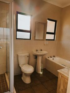a bathroom with a toilet and a sink and a tub at Sea View in Coffee Bay +15 photos