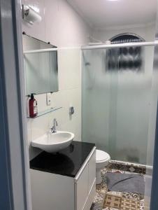 a bathroom with a sink and a shower and a toilet at Praia do Tombo - Aconchego no Guarujá in Guarujá
