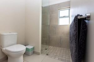 Un baño con inodoro y ducha con ventana. en Villa Boheme, Panoramic Lagoon Views, 10 Sleeper, en Langebaan