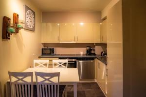 a kitchen with white cabinets and a table and chairs at Høyfjellsgrend 961, 36b in Trysil +11 photos