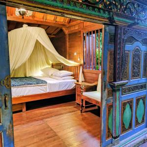a bedroom with a bed with a canopy and a chair at Villa BAgus - near Seminyak beach & trendy shops, restaurants, cafes in Seminyak