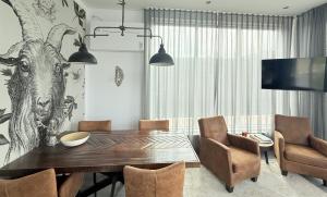 a dining room with a table and a tree mural at Woonboot 1 - Maasterp in Montfort