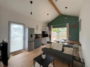 a living room with a couch and a kitchen at Maison indépendante avec cour privative in Cars