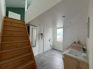 a bathroom with a staircase and a sink in a room at Maison indépendante avec cour privative in Cars