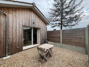a wooden building with a table next to a fence at Maison indépendante avec cour privative in Cars