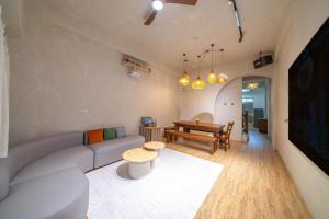 een woonkamer met een bank en een tafel bij Tainan Sunwood B&B in Anping