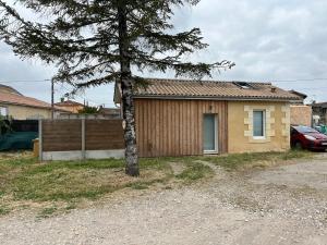 a small house with a tree in front of it at Maison indépendante avec cour privative in Cars