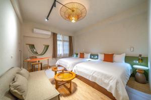 een hotelkamer met twee bedden en een bank bij Tainan Sunwood B&B in Anping +33 foto's