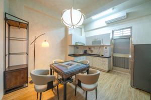 een keuken en eetkamer met een tafel en stoelen bij Tainan Sunwood B&B in Anping