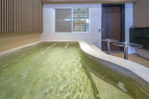 een groot zwembad met water in een kamer bij Tainan Sunwood B&B in Anping