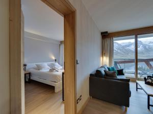 ティーニュにあるAppartement moderne au cœur de Tignes, 2 chambres, balcon, WiFi, linge fourni - FR-1-641-3のベッドとソファと窓のある寝室