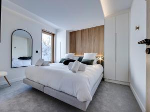 a bedroom with a large white bed and a mirror at Appartement rénové, lumineux avec terrasse, à deux pas des pistes à Tignes le Lac - FR-1-641-11 in Tignes
