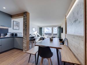 a kitchen and dining room with a table and chairs at Appartement 8 pers, skis aux pieds, balcon, rénové, proche pistes et commerces, Tignes le Lac - FR-1-641-32 in Tignes