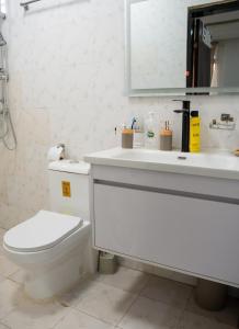 een witte badkamer met een toilet en een wastafel bij Immeuble 30 Juin in Lubumbashi