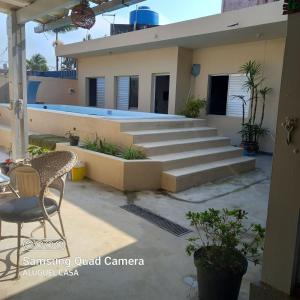 a house with stairs and a table and chairs at Pousada Estrela da Praia - Aluguel Casa in Guarujá +77 photos