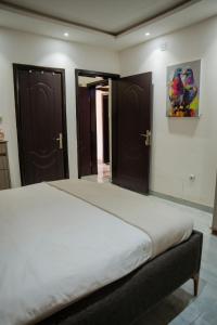een slaapkamer met een groot bed en houten deuren bij Immeuble 30 Juin in Lubumbashi