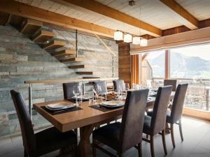 a dining room with a wooden table and chairs at Pralor Le Peille - OVO Network in Manigod