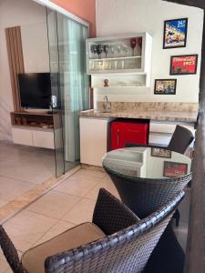 Una cocina con una mesa de cristal y sillas en una habitación. en winterville gravata, en Gravatá