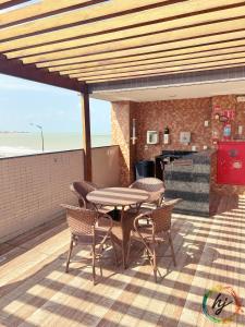 a patio with a table and chairs and a grill at Paradise Flat 114 in Nossa Senhora do Livramento