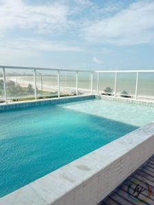 a swimming pool with a view of the ocean at Paradise Flat 114 in Nossa Senhora do Livramento +9 photos