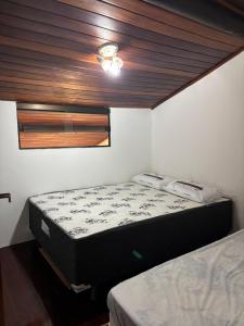 Un dormitorio con dos camas y un techo. en winterville gravata, en Gravatá