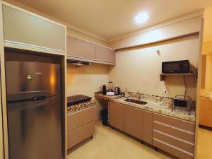 a kitchen with a stainless steel refrigerator and a microwave at Apartamento Completo Ideal para Turismo e Compras PY in Foz do Iguaçu +24 photos