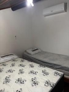 Un dormitorio con dos camas y un edredón blanco y negro. en winterville gravata, en Gravatá