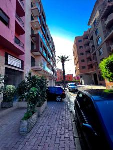 un coche aparcado en una acera junto a los edificios en Marrakech Gueliz Rue zellaqa, en Marrakech 2 fotos más