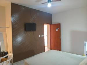 una stanza con un letto e una TV su una parete di kitnet Marilia 2 a Marília